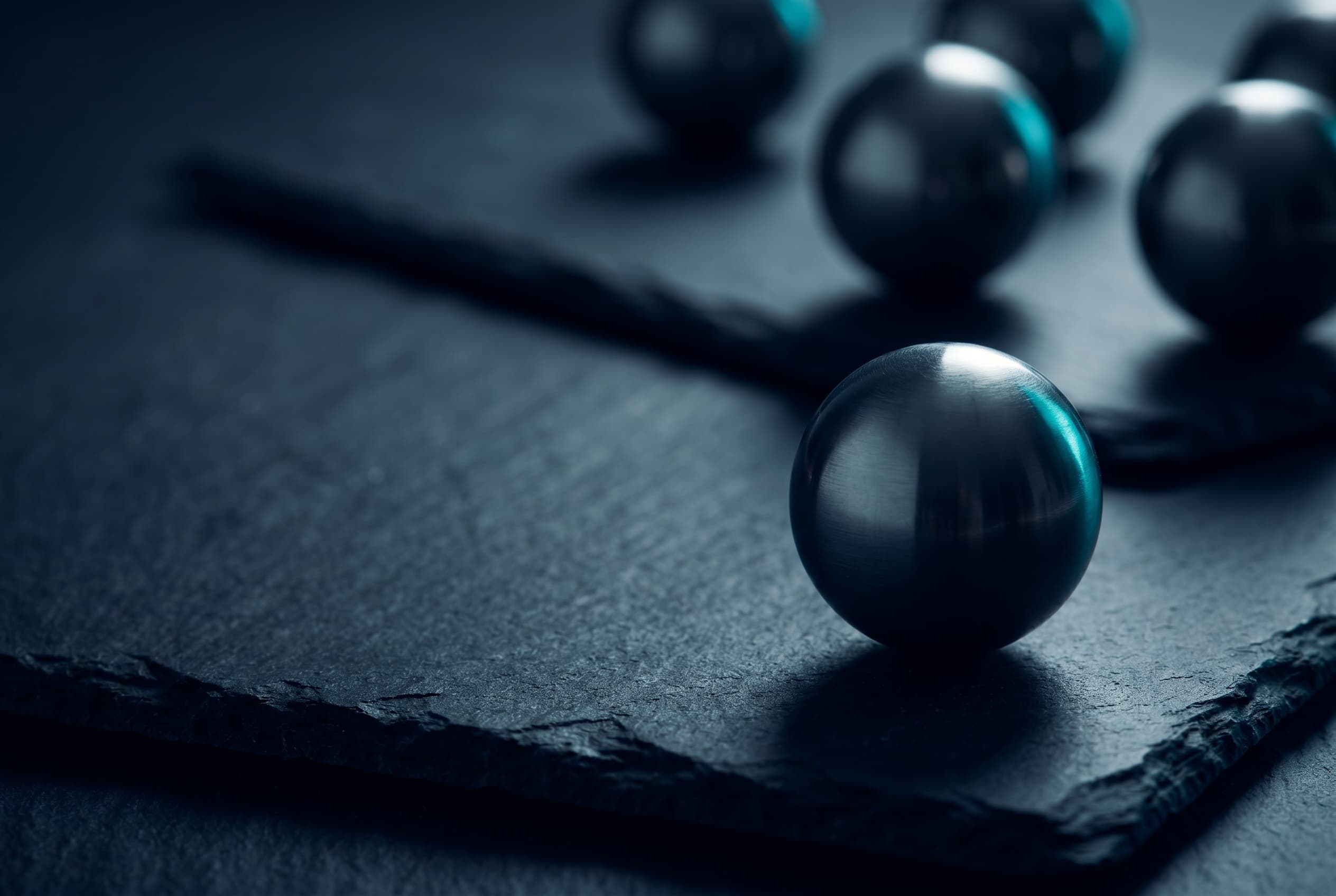 A dark sphere in sharp focus in the foreground, others blurred behind it, an image of the one exclusive focus.